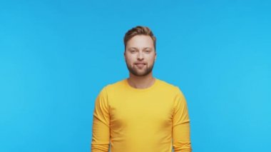 Etkileyici ve neşeli bir geçmişi olan genç adam. Gülümseyen yakışıklı kişinin stüdyo portresi.