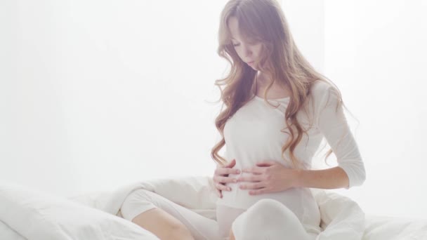 快乐的孕妇坐在床上摸着漂亮的肚子 生育和期望概念 — 图库视频影像