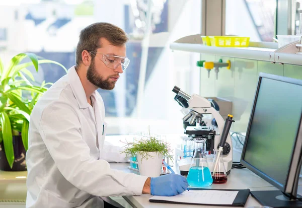 Scientist working in lab. Doctor making microbiology research. Laboratory tools: microscope, test tubes, equipment. Biotechnology, genetics, biochemistry, pharmaceutical, dna and health care concept.