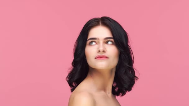 ピンクの背景に若いと美しいブルネットの女性のスタジオの肖像画 スキンケア 化粧品の概念 — ストック動画