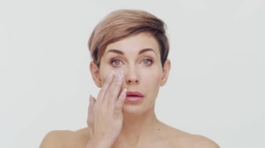 Beyaz arka planda orta yaşlı olgun bir kadının yakın çekimi. Olgun bir kadının portresi. Estetik cerrahi, güzellik enjeksiyonları, kozmetoloji konsepti.