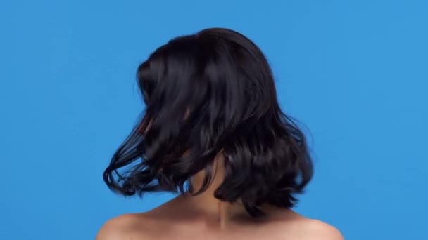 青の背景に若いと美しいブルネットの女性のスタジオの肖像画 スキンケア 化粧品の概念 — ストック動画