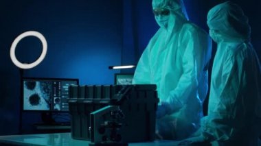 Laboratuvarda çalışan koruyucu giysi ve maskeli bilim adamları laboratuvar ekipmanları kullanıyorlardı: mikroskop, test tüpleri. İlaç, koronavirüs 2019-ncov enfeksiyonu ve aşı keşfi konsepti.