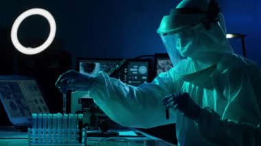 Laboratuvar ekipmanları, mikroskoplar ve test tüpleri kullanarak araştırma laboratuarında çalışan koruyucu giysi ve maskeler giyen bilim adamları. Coronavirus 2019-ncov tehlikesi, ilaç keşfi, bakteri bilimi ve virüs bilimi