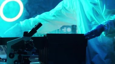 Laboratuvar ekipmanları, mikroskoplar, test tüpleri kullanarak araştırma laboratuarında çalışan koruyucu giysiler ve maskeler giyen bilim adamları. Coronavirus covid-19 tehlike, ilaç keşfi, bakteri bilimi ve virüs bilimi