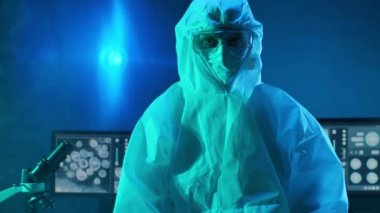 Laboratuvar ekipmanları, mikroskoplar ve test tüpleri kullanarak araştırma laboratuarında çalışan koruyucu giysi ve maskeler giyen bilim adamları. Coronavirus 2019-ncov tehlikesi, ilaç keşfi, bakteri bilimi ve virüs bilimi