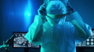 Laboratuvar ekipmanları, mikroskoplar, test tüpleri kullanarak araştırma laboratuarında çalışan koruyucu giysiler ve maskeler giyen bilim adamları. Coronavirus covid-19 tehlike, ilaç keşfi, bakteri bilimi ve virüs bilimi