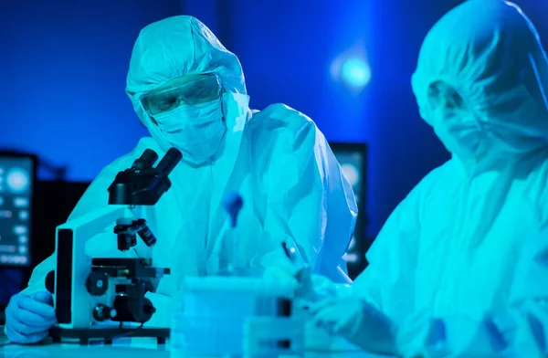 身穿防护服和戴口罩的科学家使用实验室设备在研究实验室工作 显微镜 Coronavirus 2019 Ncov感染和疫苗发现概念 — 图库照片