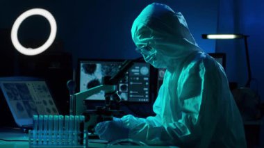 Laboratuvar ekipmanları, mikroskoplar, test tüpleri kullanarak araştırma laboratuarında çalışan koruyucu giysiler ve maskeler giyen bilim adamları. Coronavirus covid-19 tehlike, ilaç keşfi, bakteri bilimi ve virüs bilimi