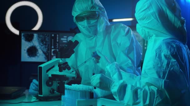 보호용 마스크를 과학자들은 실험실 현미경 시험관등을 사용하여 실험실에서 일하고 코로나 — 비디오