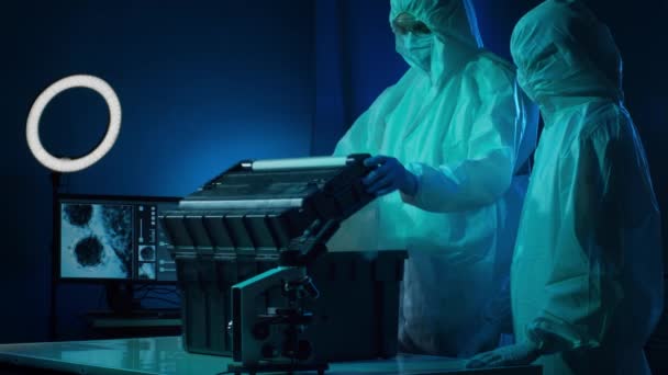 Ученые Защитных Костюмах Масках Работающие Лаборатории Использованием Лабораторного Оборудования Микроскопы — стоковое видео