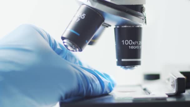 研究室のクローズアップでの科学顕微鏡 流行病 ワクチン研究とコロナウイルス Covid 19テストコンセプト — ストック動画