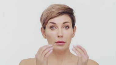 Beyaz arka planda orta yaşlı olgun bir kadının yakın çekimi. Olgun bir kadının portresi. Estetik cerrahi, güzellik enjeksiyonları, kozmetoloji konsepti.