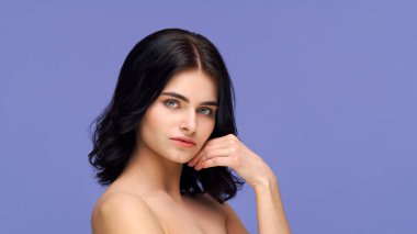 Arka planda genç ve güzel esmer kadının stüdyo portresi var. Cilt bakımı, sağlık, makyaj ve kozmetik konsepti.