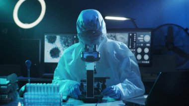 Laboratuvar ekipmanları, mikroskoplar, test tüpleri kullanarak araştırma laboratuarında çalışan koruyucu giysiler ve maskeler giyen bilim adamları. Coronavirus covid-19 tehlike, ilaç keşfi, bakteri bilimi ve virüs bilimi