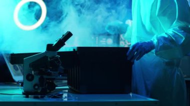 Laboratuvar ekipmanları, mikroskoplar ve test tüpleri kullanarak araştırma laboratuarında çalışan koruyucu giysi ve maskeler giyen bilim adamları. Coronavirus 2019-ncov tehlikesi, ilaç keşfi, bakteri bilimi ve virüs bilimi