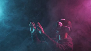 Sanal gerçeklik kaskı takmış bir adamın portresi. VR gözlüklü karanlık yüz. İnternet, darknet, oyun ve siber simülasyon kavramı.