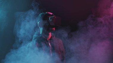 Sanal gerçeklik kaskı takmış bir adamın portresi. VR gözlüklü karanlık yüz. İnternet, darknet, oyun ve siber simülasyon kavramı.