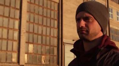 Endüstriyel binalarda ve günbatımı geçmişinde bir adamın portresi. Spor ve spor konsepti.