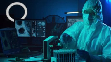 Laboratuvar ekipmanları, mikroskoplar ve test tüpleri kullanarak araştırma laboratuarında çalışan koruyucu giysi ve maskeler giyen bilim adamları. Coronavirus 2019-ncov tehlikesi, ilaç keşfi, bakteri bilimi ve virüs bilimi