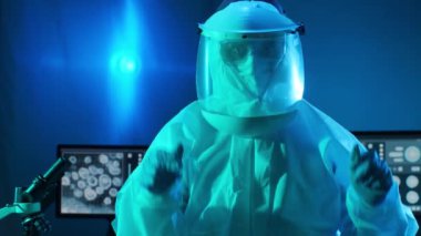 Laboratuvar ekipmanları, mikroskoplar, test tüpleri kullanarak araştırma laboratuarında çalışan koruyucu giysiler ve maskeler giyen bilim adamları. Coronavirus covid-19 tehlike, ilaç keşfi, bakteri bilimi ve virüs bilimi
