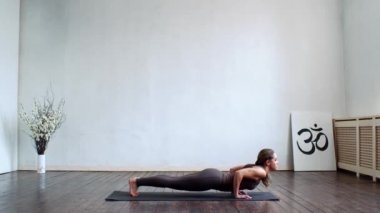 Sınıfta yoga yapan genç ve formda bir kadın. Gün ışığında esneme egzersizi. Spor, spor, sağlık hizmetleri ve yaşam tarzı kavramları.
