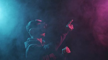 Sanal gerçeklik kaskı takmış bir adamın portresi. VR gözlüklü karanlık yüz. İnternet, darknet, oyun ve siber simülasyon kavramı.