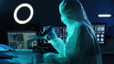 Laboratuvar ekipmanları, mikroskoplar ve test tüpleri kullanarak araştırma laboratuarında çalışan koruyucu giysi ve maskeler giyen bilim adamları. Coronavirus 2019-ncov tehlikesi, ilaç keşfi, bakteri bilimi ve virüs bilimi
