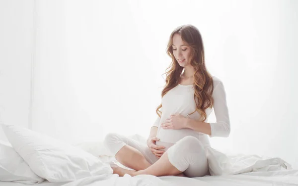 Szczęśliwa Ciężarna Kobieta Dotykająca Swojego Pięknego Brzucha Siedzącego Łóżku Ciąża — Zdjęcie stockowe