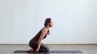 Sınıfta yoga yapan genç ve formda bir kadın. Gün ışığında esneme egzersizi. Spor, spor, sağlık hizmetleri ve yaşam tarzı kavramları.
