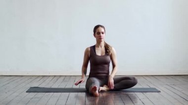 Sınıfta yoga yapan genç ve formda bir kadın. Gün ışığında esneme egzersizi. Spor, spor, sağlık hizmetleri ve yaşam tarzı kavramları.