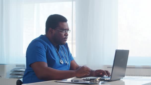 아프리카 미국인 의사는 컴퓨터 기술을 사용하여 병원에서 일한다 — 비디오