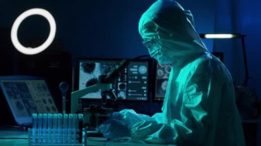 Laboratuvar ekipmanları, mikroskoplar, test tüpleri kullanarak araştırma laboratuarında çalışan koruyucu giysiler ve maskeler giyen bilim adamları. Coronavirus covid-19 tehlike, ilaç keşfi, bakteri bilimi ve virüs bilimi
