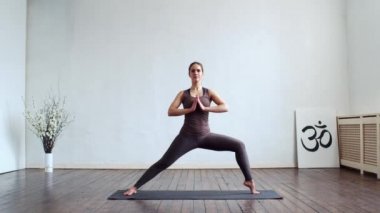 Sınıfta yoga yapan genç ve formda bir kadın. Gün ışığında esneme egzersizi. Spor, spor, sağlık hizmetleri ve yaşam tarzı kavramları.