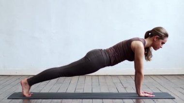 Sınıfta yoga yapan genç ve formda bir kadın. Gün ışığında esneme egzersizi. Spor, spor, sağlık hizmetleri ve yaşam tarzı kavramları.