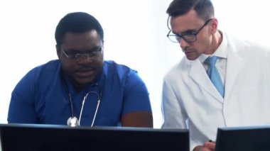 Doktor ve cerrah hastane ofisinde bilgisayar teknolojisi kullanıyorlardı. Klinikte sağlık çalışanları. Gün ışığı. Sağlık, tıp, takım çalışması kavramları.