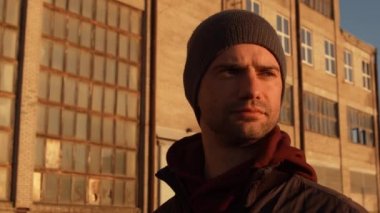 Endüstriyel binalarda ve günbatımı geçmişinde bir adamın portresi. Spor ve spor konsepti.