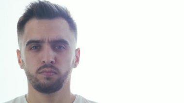 Pencere arkasında etkileyici bir genç adam. Gülümseyen yakışıklı birinin ev resmi. Doğal gün ışığı.