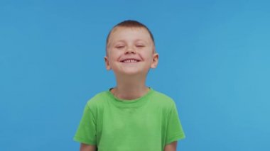 Tişörtlü mutlu gülümseyen çocuğun portresi. Stüdyodaki çekici ve etkileyici çocuk. Çocukluk kavramı.