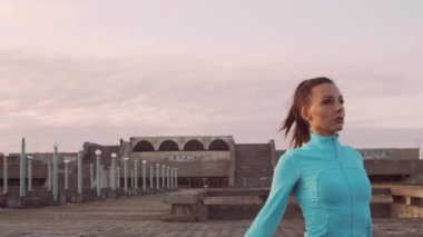 Genç, güzel ve sportif bir kadın dışarıda akşam antrenmanı yapıyor. Şehir günbatımı geçmişi. Spor ve spor konsepti.