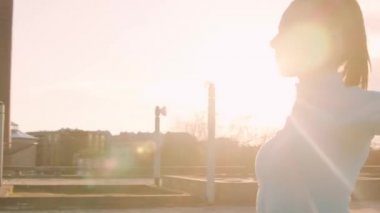 Genç, güzel ve sportif bir kadın dışarıda akşam antrenmanı yapıyor. Şehir günbatımı geçmişi. Spor ve spor konsepti.