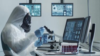 Laboratuvar ekipmanları, mikroskoplar ve test tüpleri kullanarak araştırma laboratuarında çalışan koruyucu giysi ve maskeler giyen bilim adamları. Coronavirus 2019-ncov tehlikesi, ilaç keşfi, bakteri bilimi ve virüs bilimi
