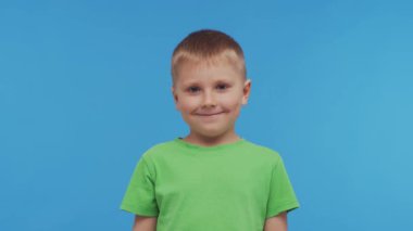 Tişörtlü mutlu gülümseyen çocuğun portresi. Stüdyodaki etkileyici çocuk. Çocukluk kavramı.