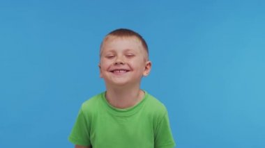 Tişörtlü mutlu gülümseyen çocuğun portresi. Stüdyodaki çekici ve etkileyici çocuk. Çocukluk kavramı.