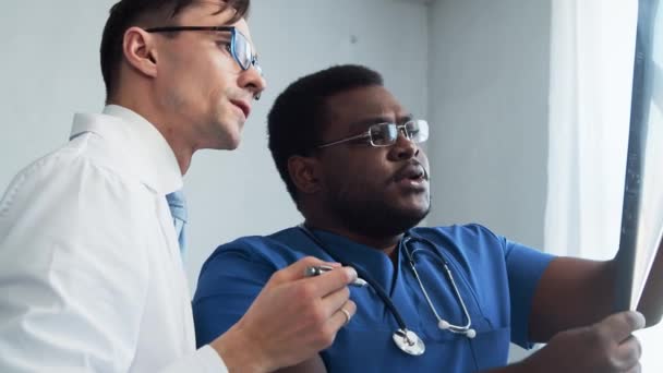 Dokter Chirurg Praten Bij Het Raam Kijken Naar Röntgenfoto Medische — Stockvideo