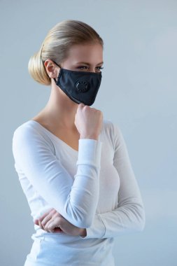 Tıbbi maskeli genç ve doğal bir kadının portresi. Güzel gün ışığı. Salgın, koronavirüs, covid-19 ve koruma konsepti..