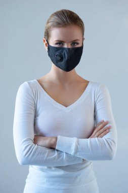 Tıbbi maskeli genç ve doğal bir kadının portresi. Güzel gün ışığı. Salgın, koronavirüs, covid-19 ve koruma konsepti..