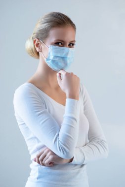 Tıbbi maskeli genç ve doğal bir kadının portresi. Güzel gün ışığı. Salgın, koronavirüs, covid-19 ve koruma konsepti..