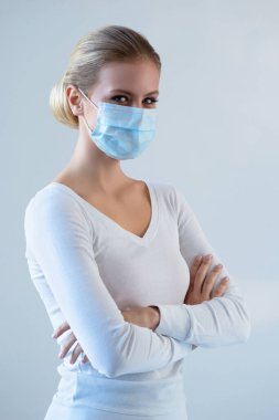 Tıbbi maskeli genç ve doğal bir kadının portresi. Güzel gün ışığı. Salgın, koronavirüs, covid-19 ve koruma konsepti..