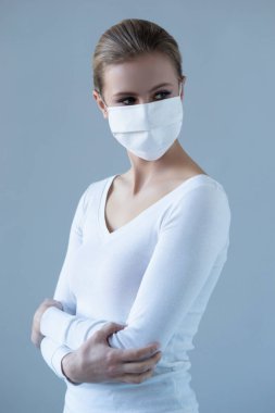 Tıbbi maskeli genç ve doğal bir kadının portresi. Güzel gün ışığı. Salgın, koronavirüs, covid-19 ve koruma konsepti..
